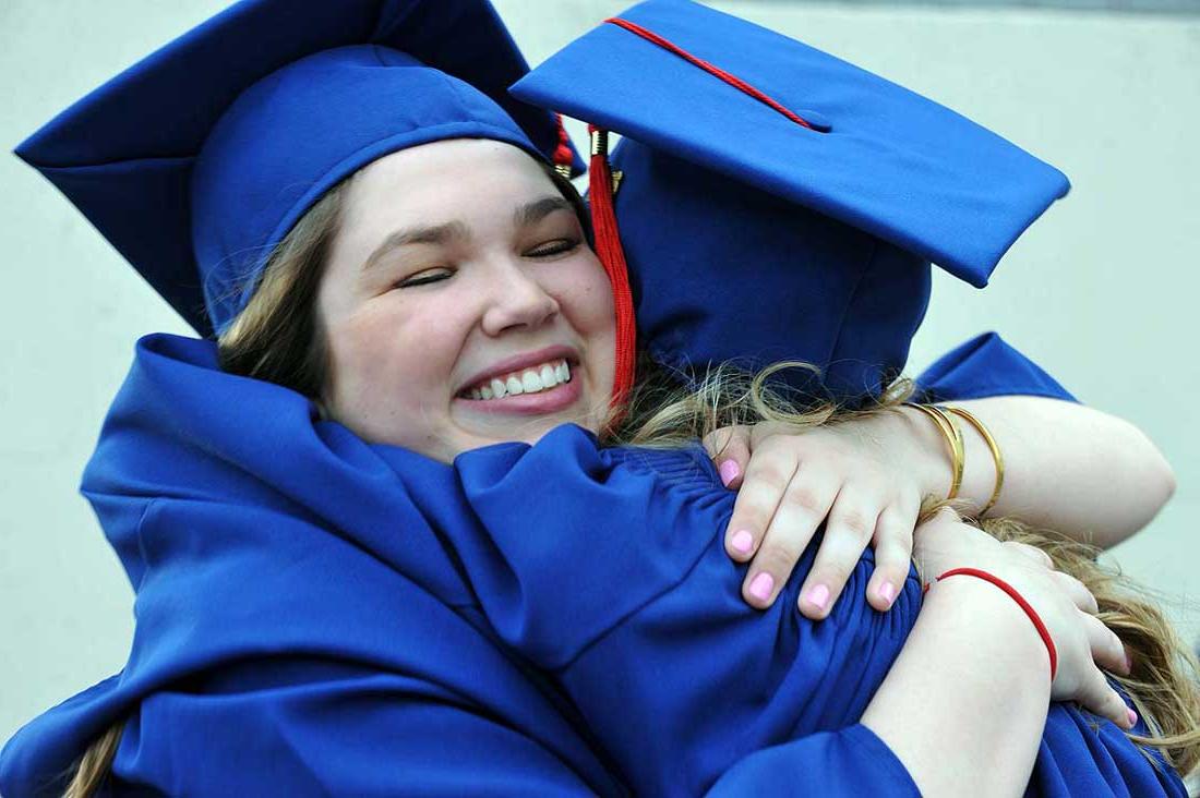 Graduates hug after the 2016 Commencement.